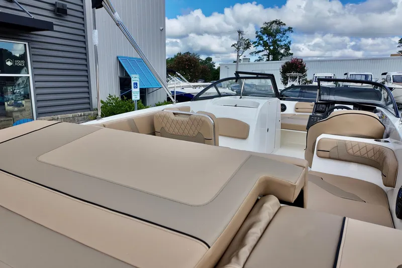 Slide: The Image of 2026 Bayliner VR6 boat with beige seating, displayed outdoors near a building. - 18