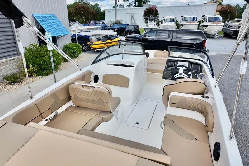 Slide: The Image of 2026 Bayliner VR6 boat interior with beige seating and modern dashboard, displayed outdoors. - 6