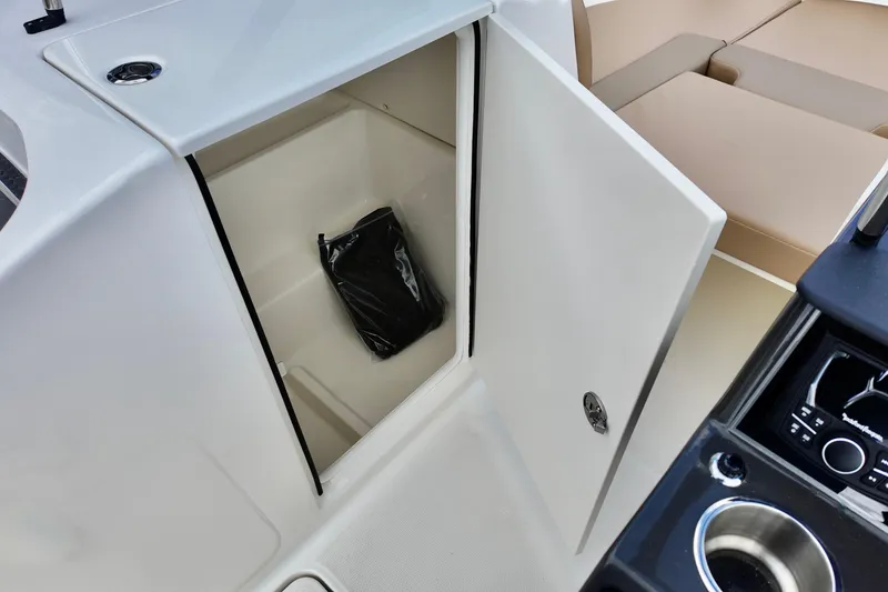 Slide: The Image of Open storage compartment on 2026 Bayliner VR6 boat, showing interior space and a black bag. - 8