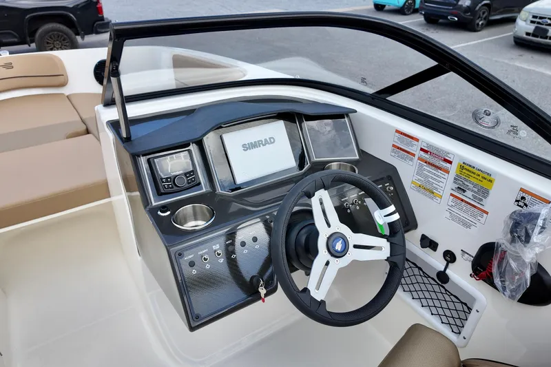 Slide: The Image of 2026 Bayliner VR6 boat dashboard with steering wheel and Simrad navigation system. - 9