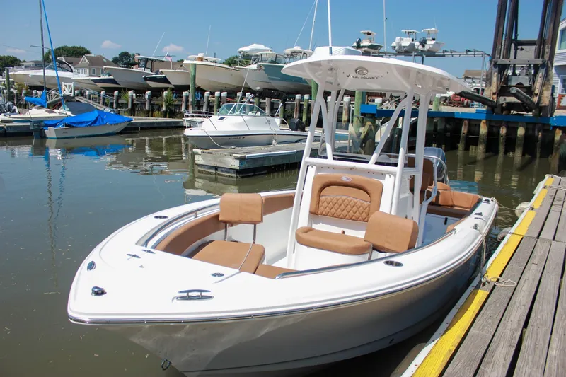 The Image of 2026 Sea Hunt Ultra 219 boat docked at a marina, featuring sleek design and comfortable seating. - 0