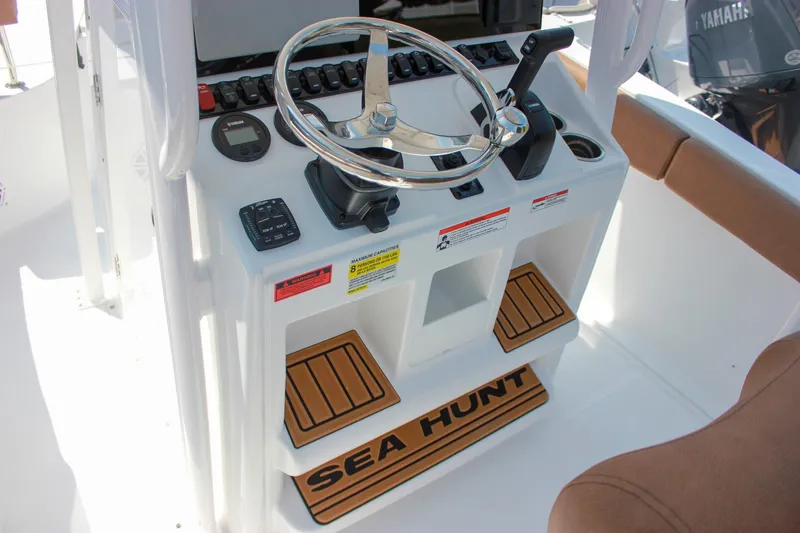 Slide: The Image of 2026 Sea Hunt Ultra 219 boat console with steering wheel and controls. - 13