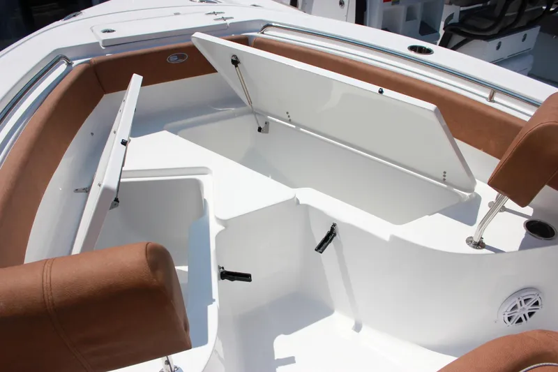 Slide: The Image of 2026 Sea Hunt Ultra 219 boat interior with open storage compartments and brown seating. - 15
