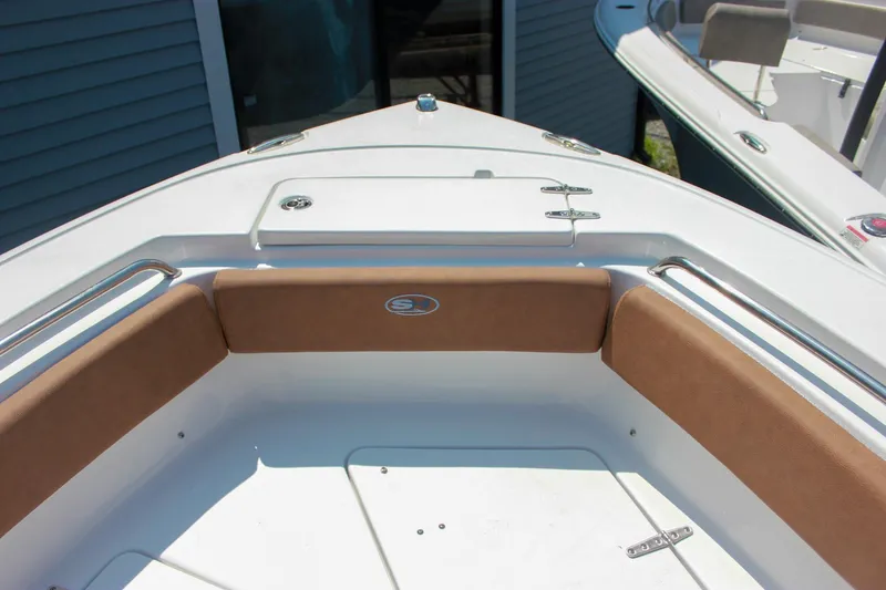 Slide: The Image of 2026 Sea Hunt Ultra 219 boat interior with cushioned seating and storage compartment. - 19