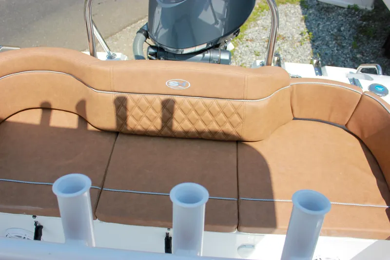 Slide: The Image of 2026 Sea Hunt Ultra 219 boat with tan cushioned seating and rod holders. - 24