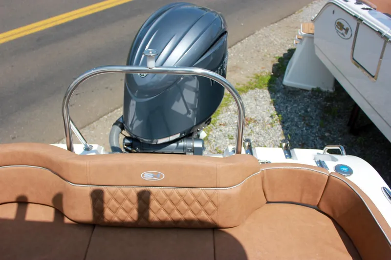 Slide: The Image of 2026 Sea Hunt Ultra 219 boat with tan seating and powerful outboard motor. - 25