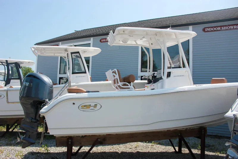 Slide: The Image of 2026 Sea Hunt Ultra 219 boat displayed outdoors near showroom. - 28