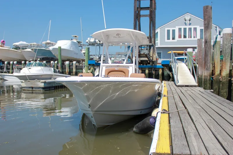 Slide: The Image of 2026 Sea Hunt Ultra 219 boat docked at a marina under clear blue skies. - 3
