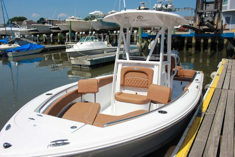 Slide: The Image of 2026 Sea Hunt Ultra 219 boat docked, featuring sleek design and comfortable seating. - 31