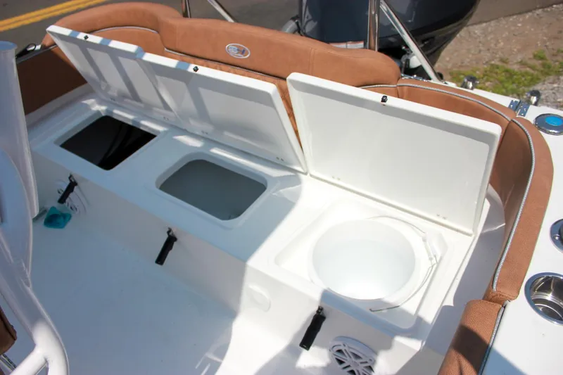 Slide: The Image of 2026 Sea Hunt Ultra 219 boat storage compartments with open lids, showcasing interior features. - 9
