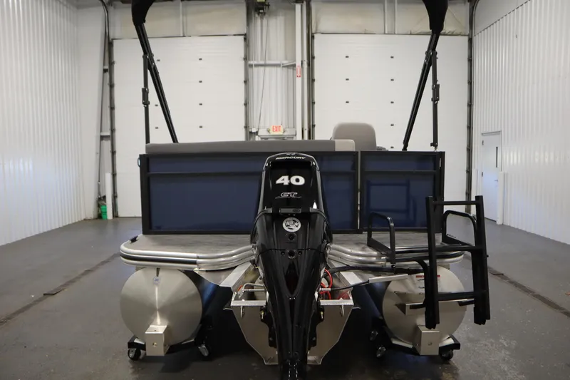 Slide: The Image of 2026 Lowe LS 170 pontoon boat with a 40 HP Mercury outboard motor in a garage. - 5