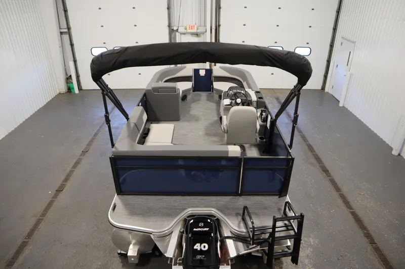 Slide: The Image of 2026 Lowe LS 170 pontoon boat with canopy in a garage setting. - 9