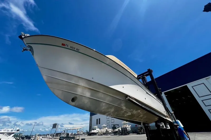 Slide: The Image of 2015 Grady-White Canyon 336 boat lifted at marina under clear blue sky. - 14