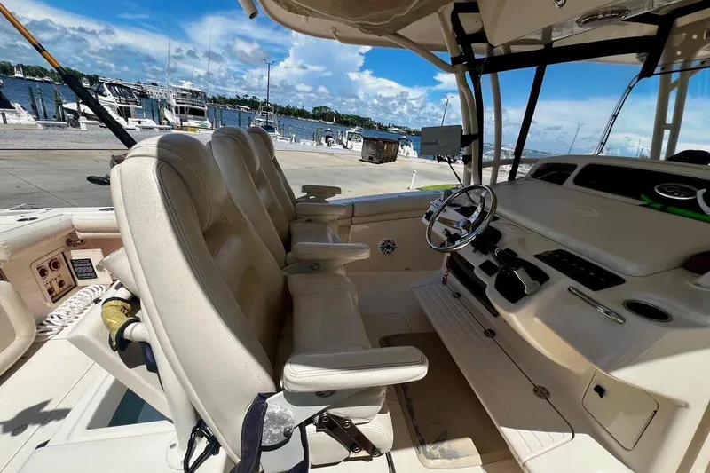 Slide: The Image of 2015 Grady-White Canyon 336 boat interior with helm and seating, docked by the marina. - 20