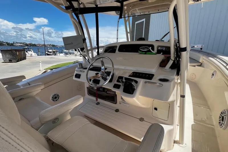Slide: The Image of 2015 Grady-White Canyon 336 boat cockpit with steering wheel and navigation equipment. - 27