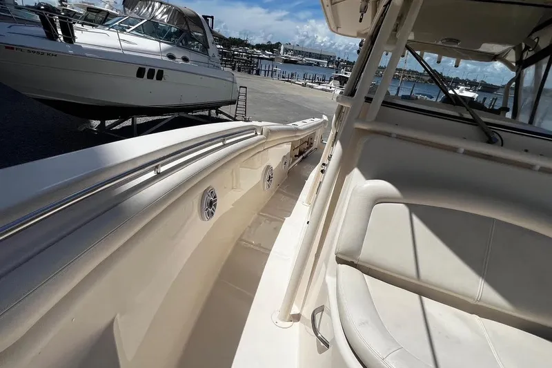 Slide: The Image of 2015 Grady-White Canyon 336 boat interior with seating, docked near other vessels. - 35