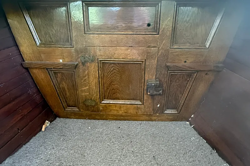 Slide: The Image of Wooden interior of 1904 Fay & Bowen Torpedo Launch, featuring detailed paneling and latch. - 16