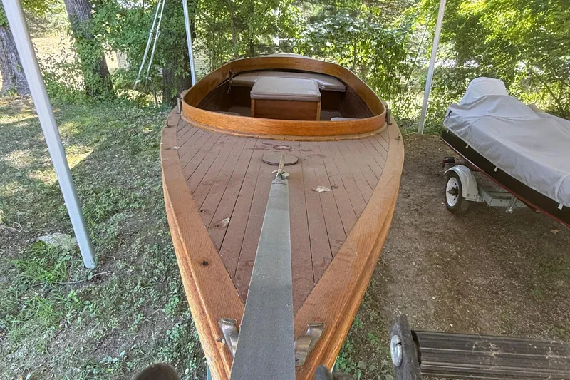 Slide: The Image of 1904 Fay & Bowen Torpedo Launch, wooden deck, under canopy, surrounded by greenery. - 24
