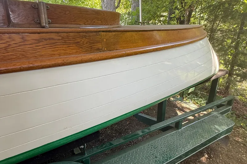 Slide: The Image of 1904 Fay & Bowen Torpedo Launch with wooden detailing on display outdoors. - 4