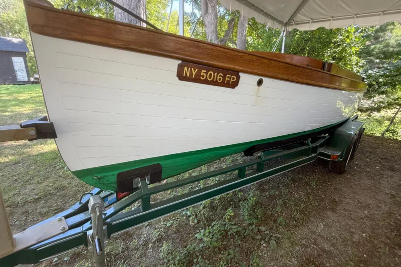 Slide: The Image of 1904 Fay & Bowen Torpedo Launch on trailer, white hull, wooden trim, under canopy. - 6