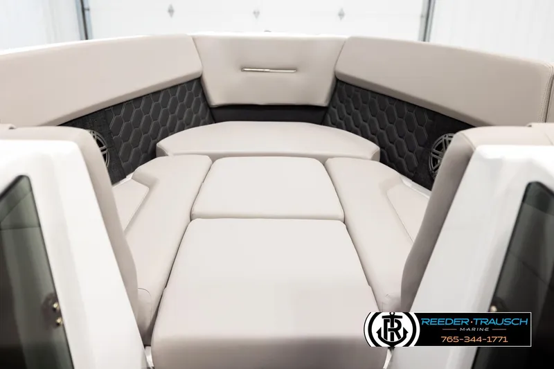 Slide: The Image of 2024 Four Winns H4 boat interior with beige seating and hexagonal pattern accents. - 17