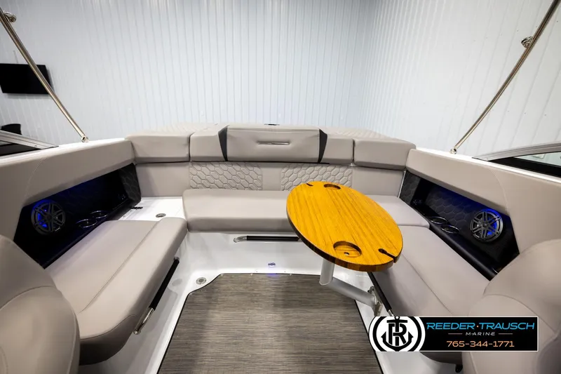 Slide: The Image of 2024 Four Winns H4 boat interior with beige seating and wooden table. - 21
