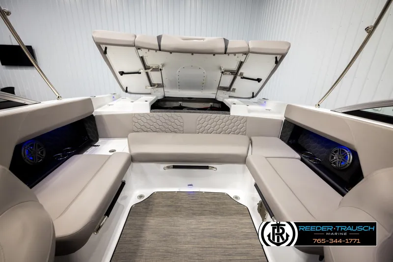 Slide: The Image of 2024 Four Winns H4 boat interior with beige seating and open storage compartment. - 22