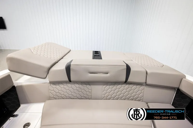 Slide: The Image of 2024 Four Winns H4 boat interior with beige cushioned seating and hexagonal stitching. - 24