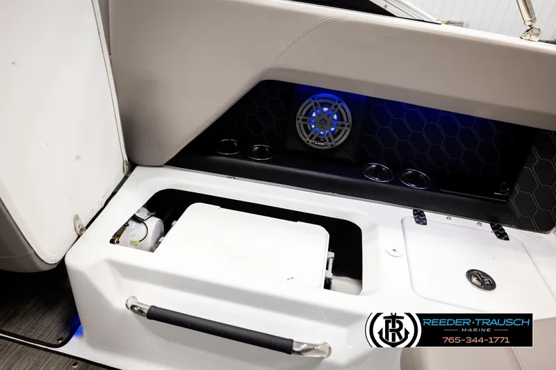 Slide: The Image of 2024 Four Winns H4 boat interior with storage compartment and speaker system. - 28