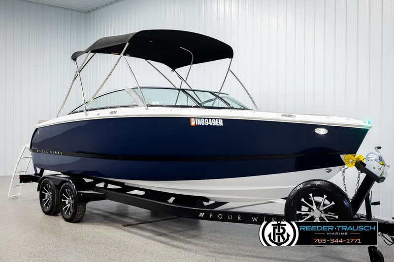 Slide: The Image of 2024 Four Winns H4 boat with black canopy on trailer in showroom. - 3