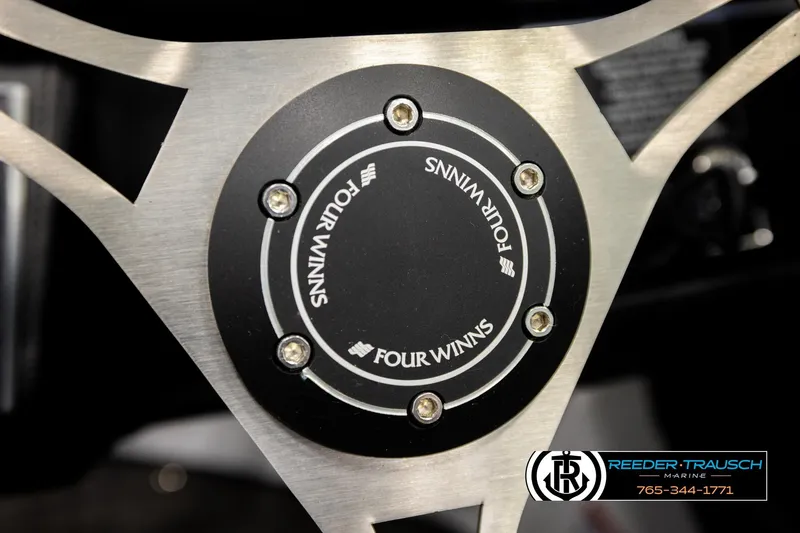 Slide: The Image of 2024 Four Winns H4 steering wheel detail with logo and metallic accents. - 35