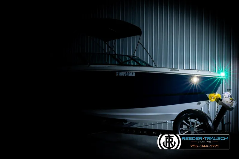 Slide: The Image of 2024 Four Winns H4 boat in dimly lit storage, highlighting sleek design. - 4