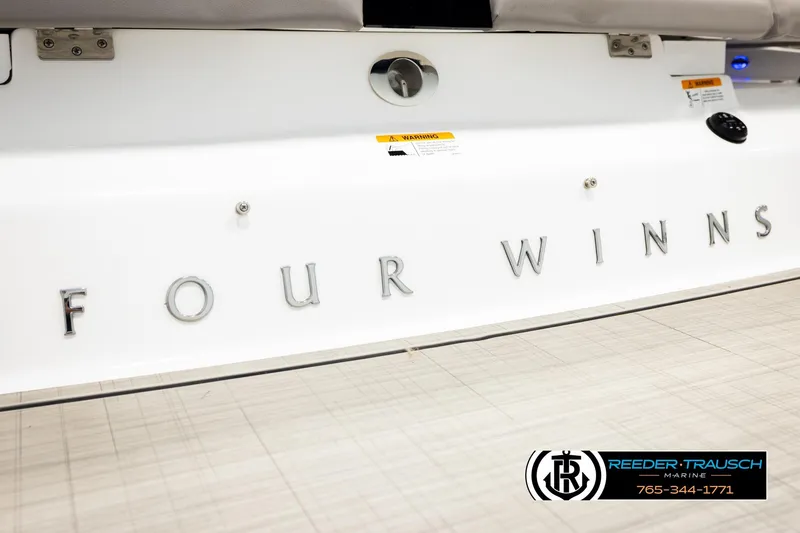Slide: The Image of 2024 Four Winns H4 boat rear view with logo and Reeder-Trausch Marine branding. - 51