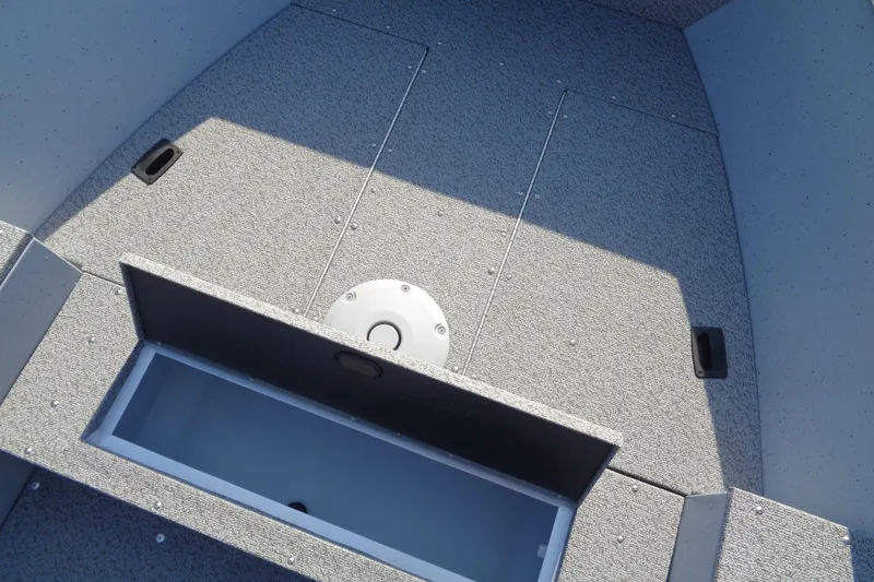 Slide: The Image of 2026 Lund 1400 Fury Tiller boat interior with storage compartment and textured flooring. - 11