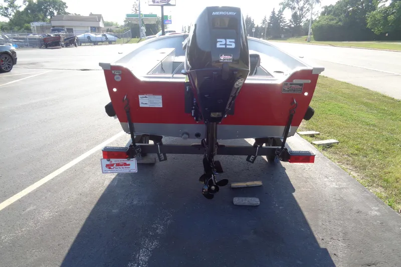Slide: The Image of 2026 Lund 1400 Fury Tiller boat with Mercury 25 engine, parked on a trailer. - 3