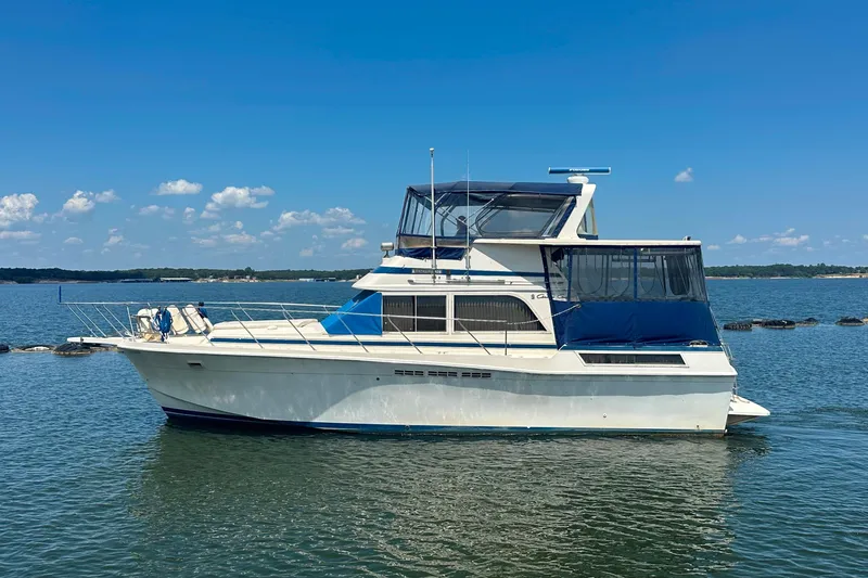 The Image of 1985 Chris-Craft 426 Catalina yacht on calm water under clear blue sky. - 0