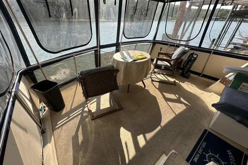 Slide: The Image of 1985 Chris-Craft 426 Catalina interior with chairs and table, overlooking serene water view. - 10