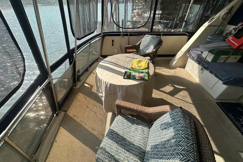 Slide: The Image of 1985 Chris-Craft 426 Catalina interior with seating, table, and lake view. - 11
