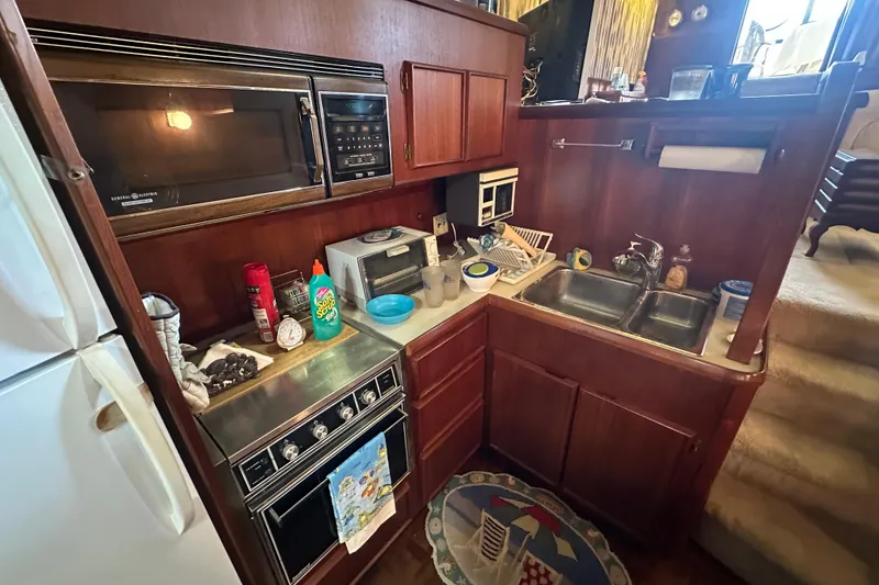 Slide: The Image of 1985 Chris-Craft 426 Catalina kitchen with microwave, stove, and double sink. - 30