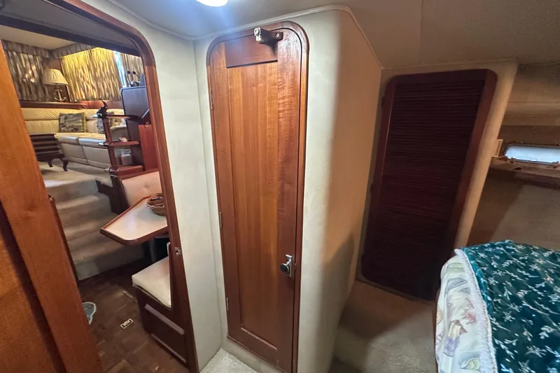 Slide: The Image of 1985 Chris-Craft 426 Catalina interior with wood paneling and cozy seating area. - 38