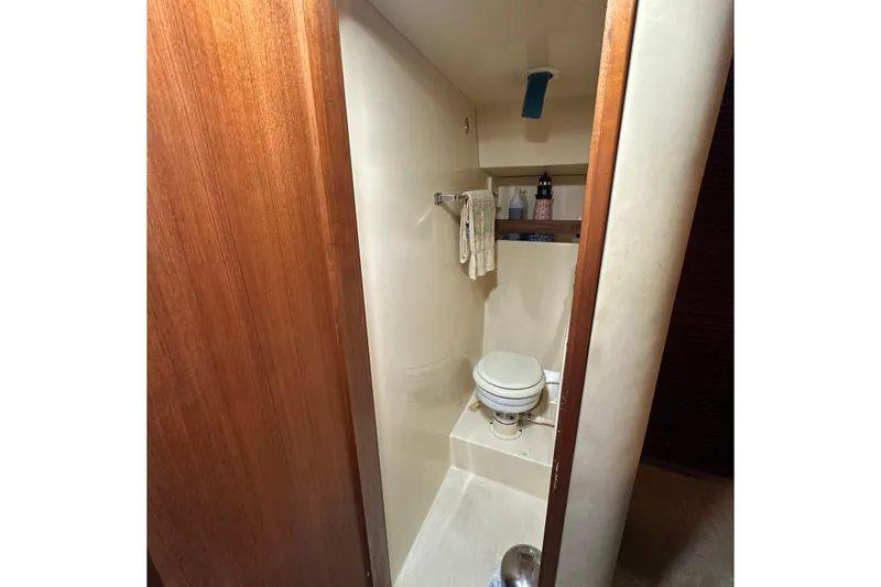Slide: The Image of 1985 Chris-Craft 426 Catalina bathroom interior with toilet and wooden accents. - 39
