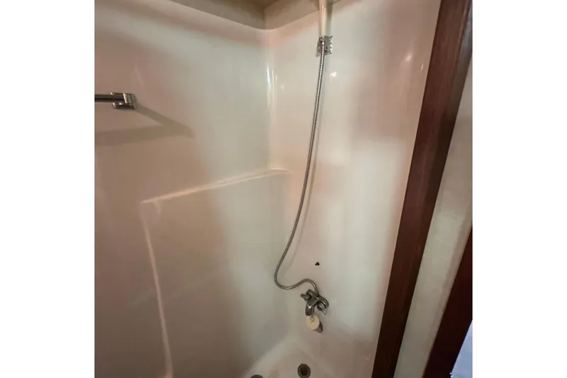 Slide: The Image of Shower area in 1985 Chris-Craft 426 Catalina yacht, featuring a handheld showerhead. - 47