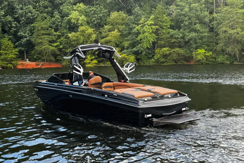 Slide: The Image of 2020 Centurion Ri257 boat cruising on a scenic lake with lush green forest backdrop. - 10