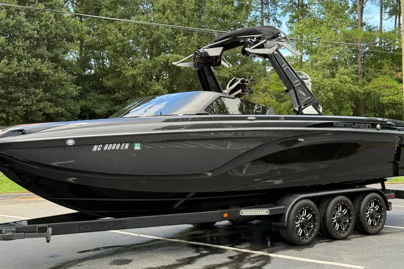 Slide: The Image of 2020 Centurion Ri257 boat on trailer, sleek black design, parked outdoors. - 11