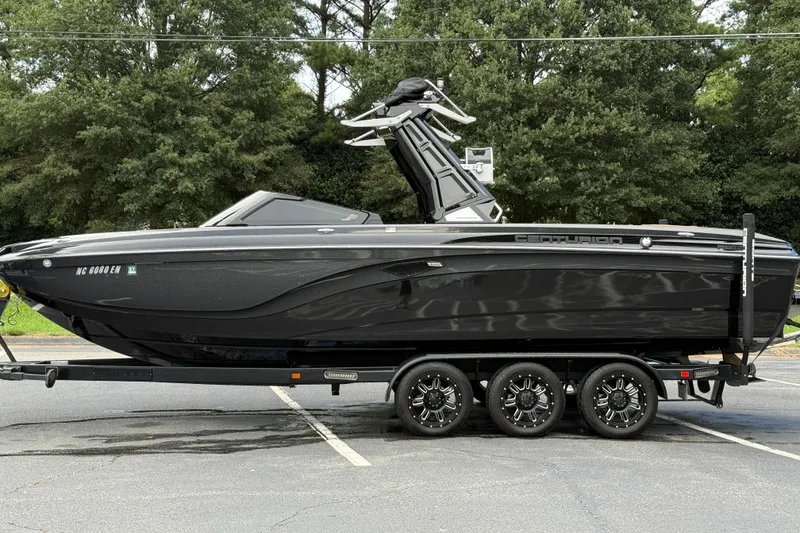 Slide: The Image of 2020 Centurion Ri257 boat on trailer, sleek black design, parked outdoors. - 12