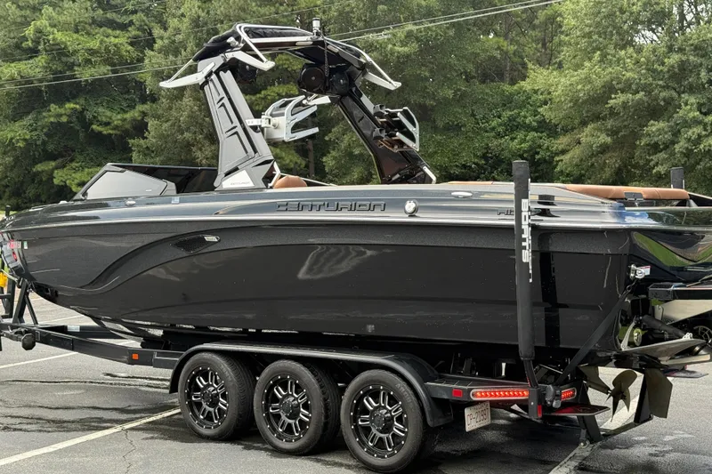 Slide: The Image of 2020 Centurion Ri257 boat on trailer, sleek black design, parked outdoors. - 13