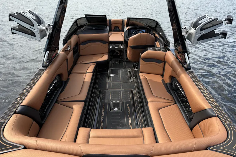 Slide: The Image of 2020 Centurion Ri257 boat interior with luxurious tan seating and sleek design on water. - 21