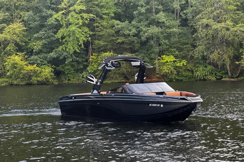 Slide: The Image of 2020 Centurion Ri257 boat cruising on a scenic lake with lush green trees. - 3