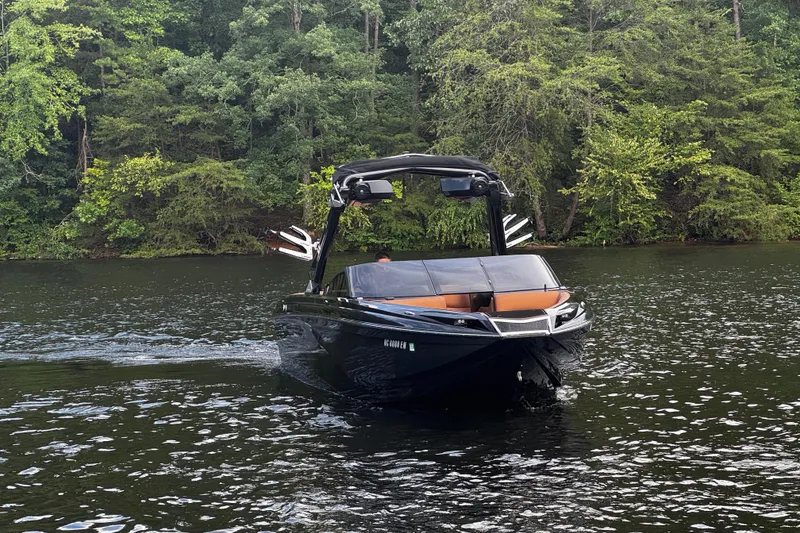 Slide: The Image of 2020 Centurion Ri257 boat cruising on a serene lake with lush green forest backdrop. - 4