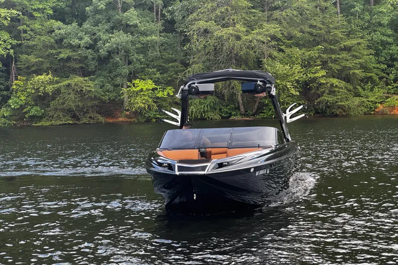 Slide: The Image of 2020 Centurion Ri257 boat cruising on a serene lake with lush green forest backdrop. - 5